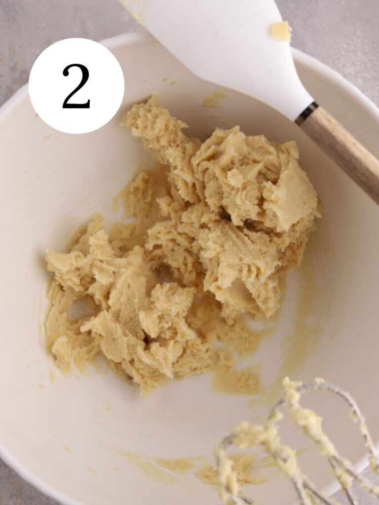 Creamed butter and sugar in a mixing bowl with a spatula.