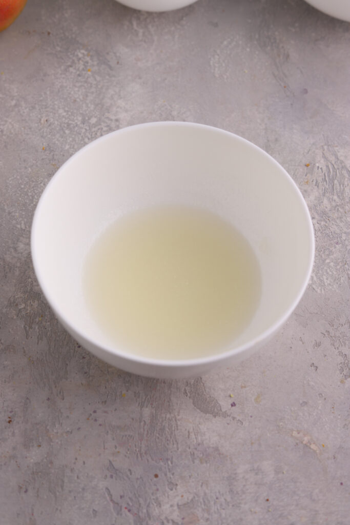 Gelatin being bloomed in a white bowl. 