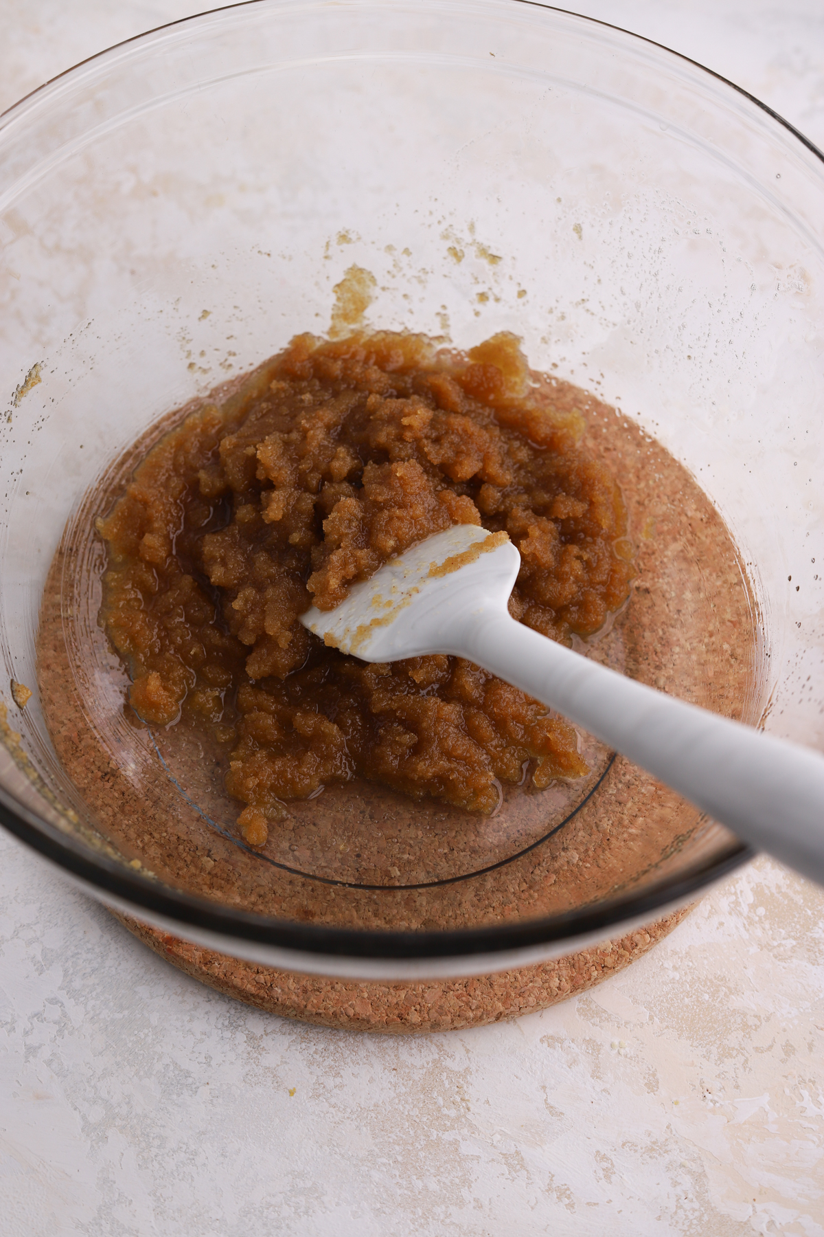 Butter and brown sugar mixed together with a spatula in a bowl. 