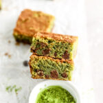 Matcha brownies with chocolate chips and a small bowl of matcha powder.