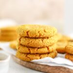 A stack of golden turmeric cookies on a platter.