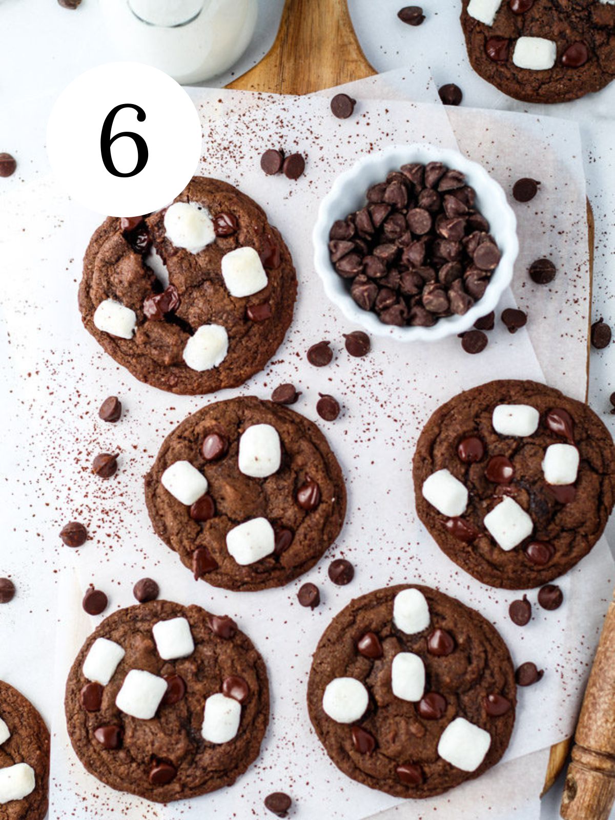 Marshmallow chocolate chip cookies on a tray with a bowl of chocolate chips.
