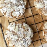 Powdered sugar covered crinkle cookies on a wire rack.