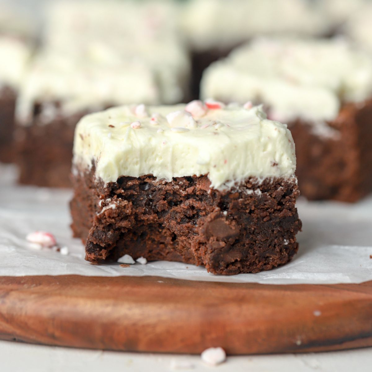 A brownie topped with frosting with a bite taken out of it.
