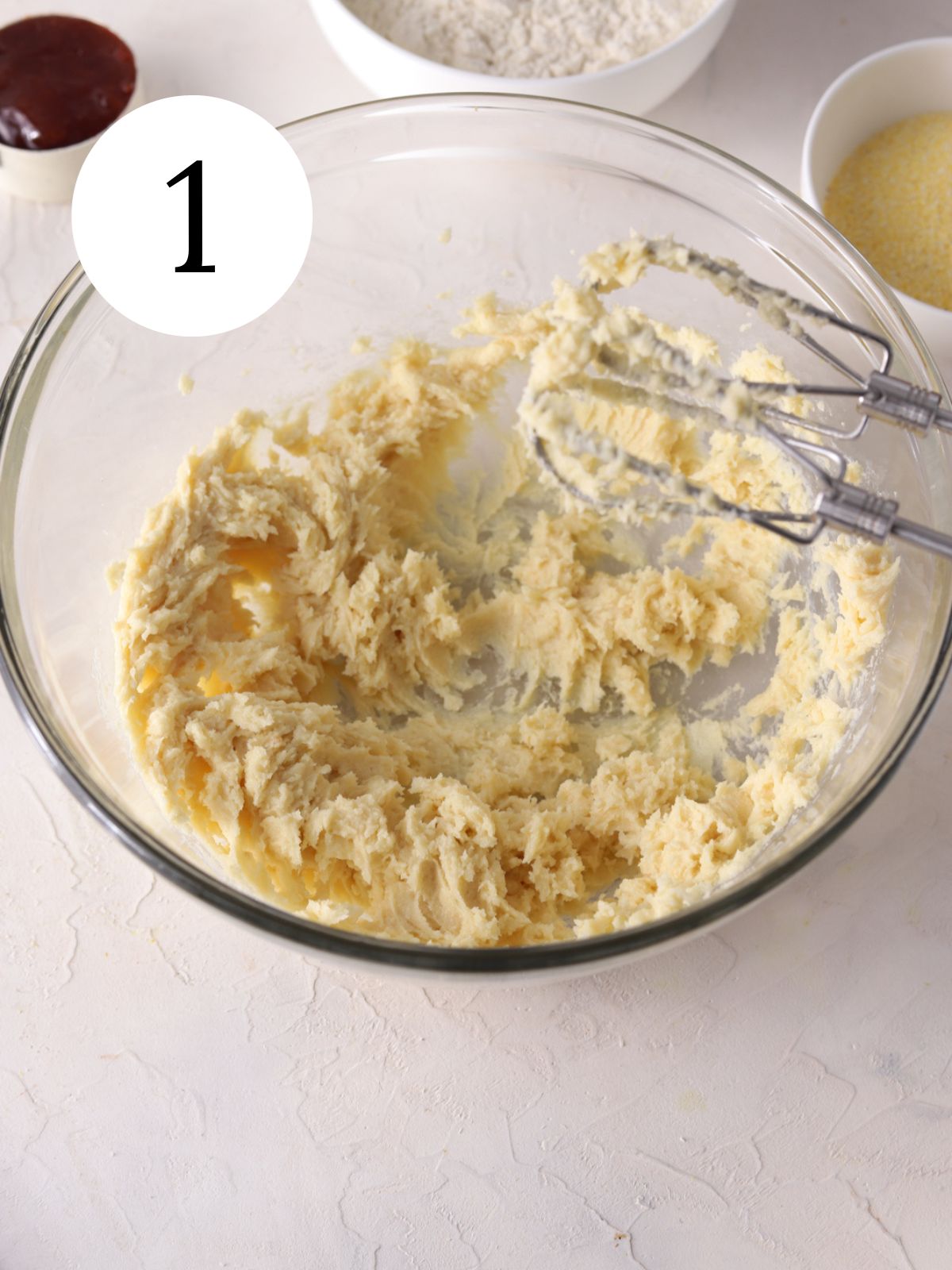 Butter and sugars creamed in a glass mixing bowl. 