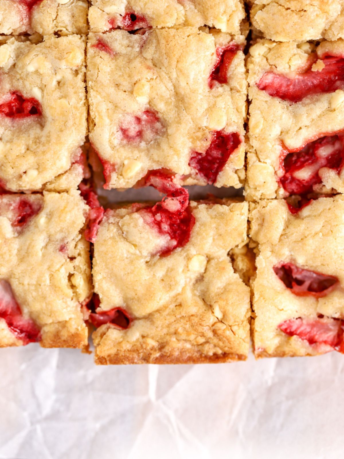 Golden strawberry blondies cut into squares.