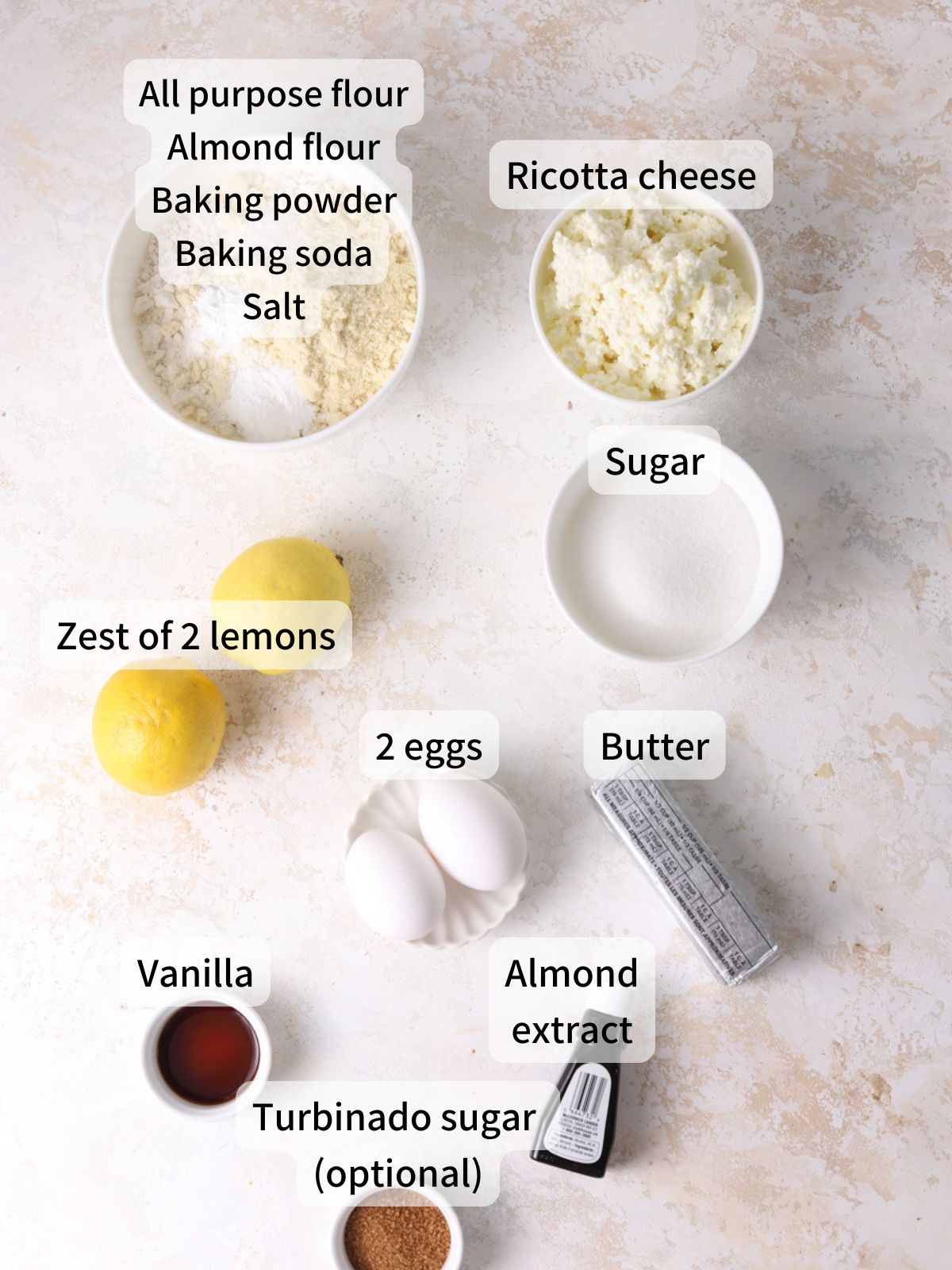Labeled ingredients needed to make lemon ricotta muffins laid out on a table.