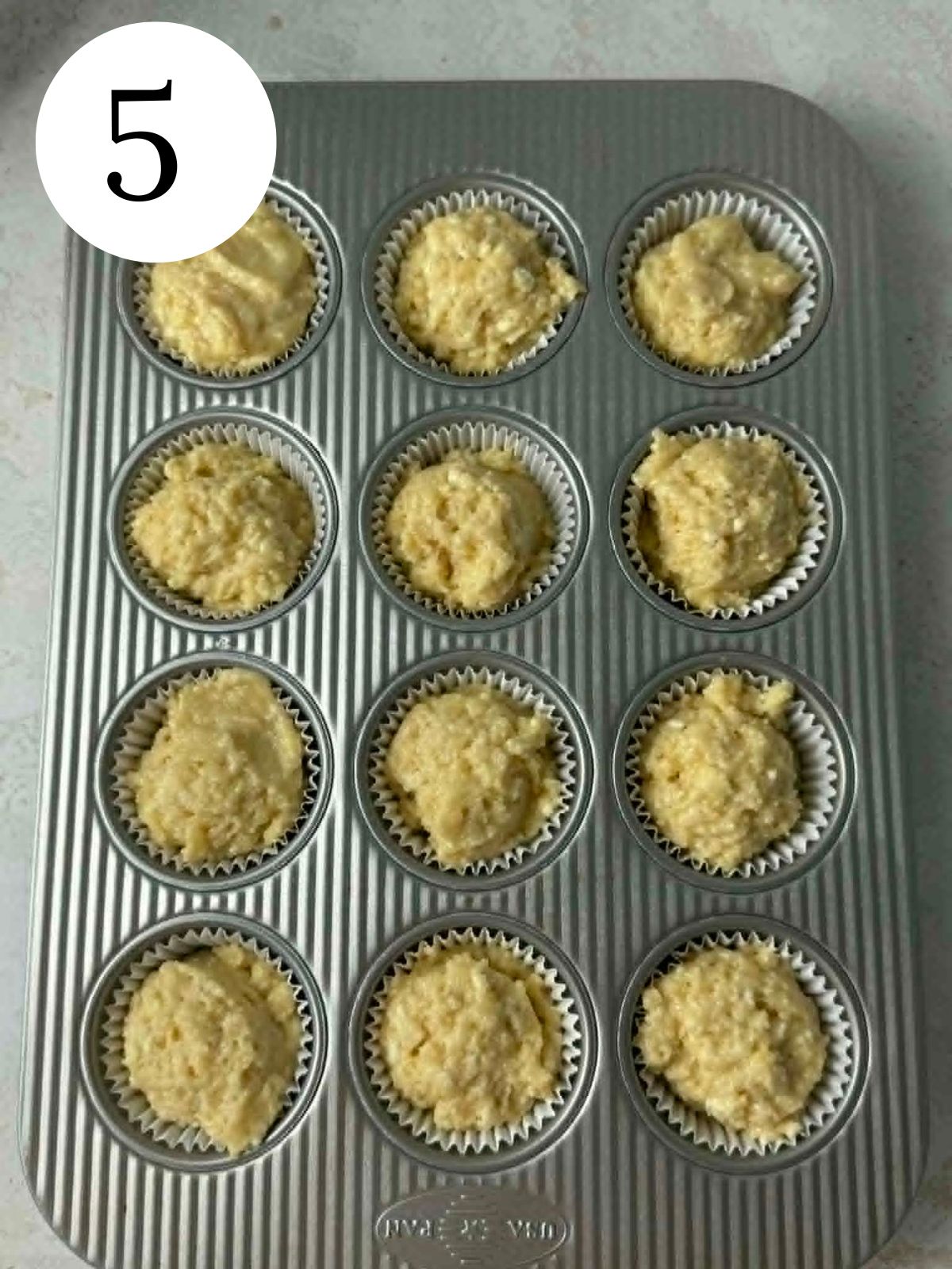 A muffin pan filled with muffin liners and batter.