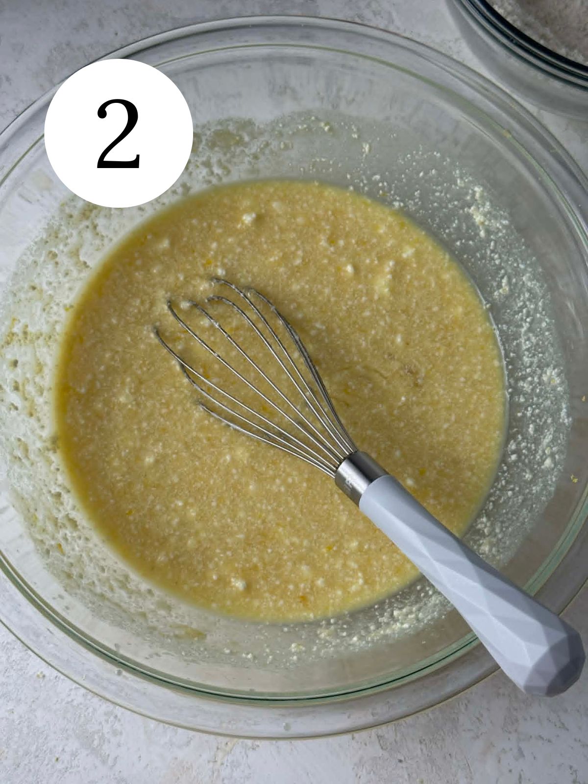 Wet ingredients mixed together with a whisk in a bowl.