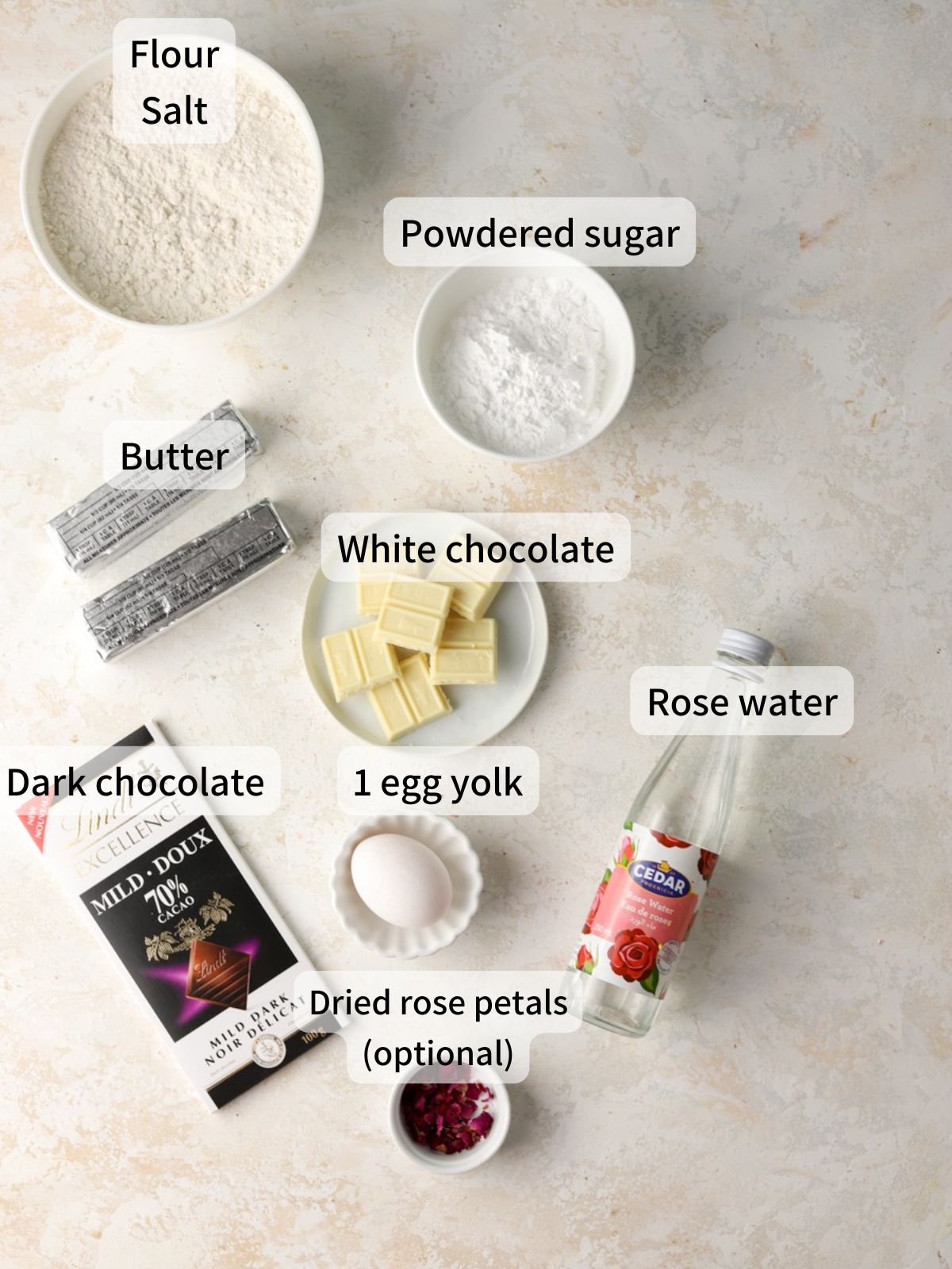 Labeled ingredients needed to make rose cookies laid out on a table.
