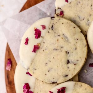Chocolate shortbread cookies dipped in white chocolate topped with rose petals.