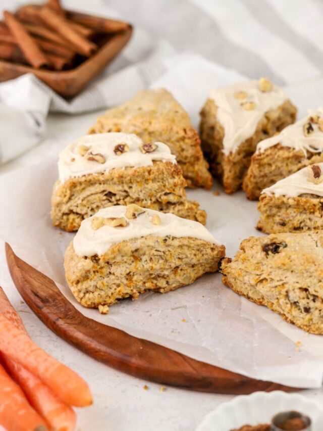 A batch of scones topped with icing and walnuts.