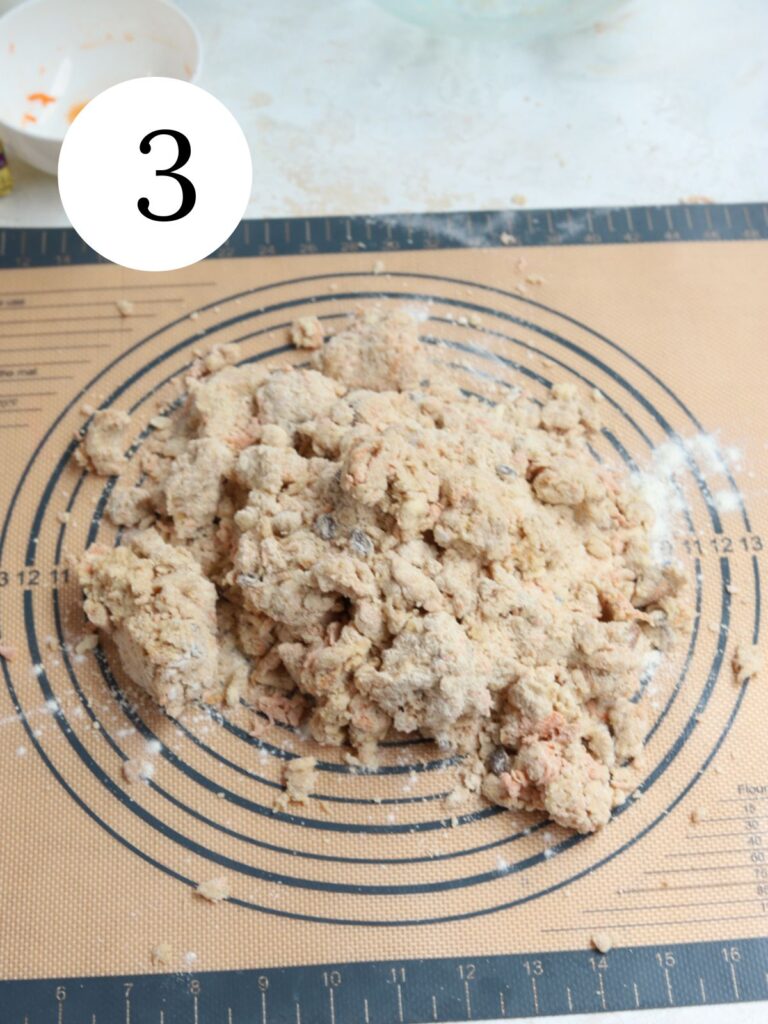 Dough on a pastry mat next to a small white bowl. 