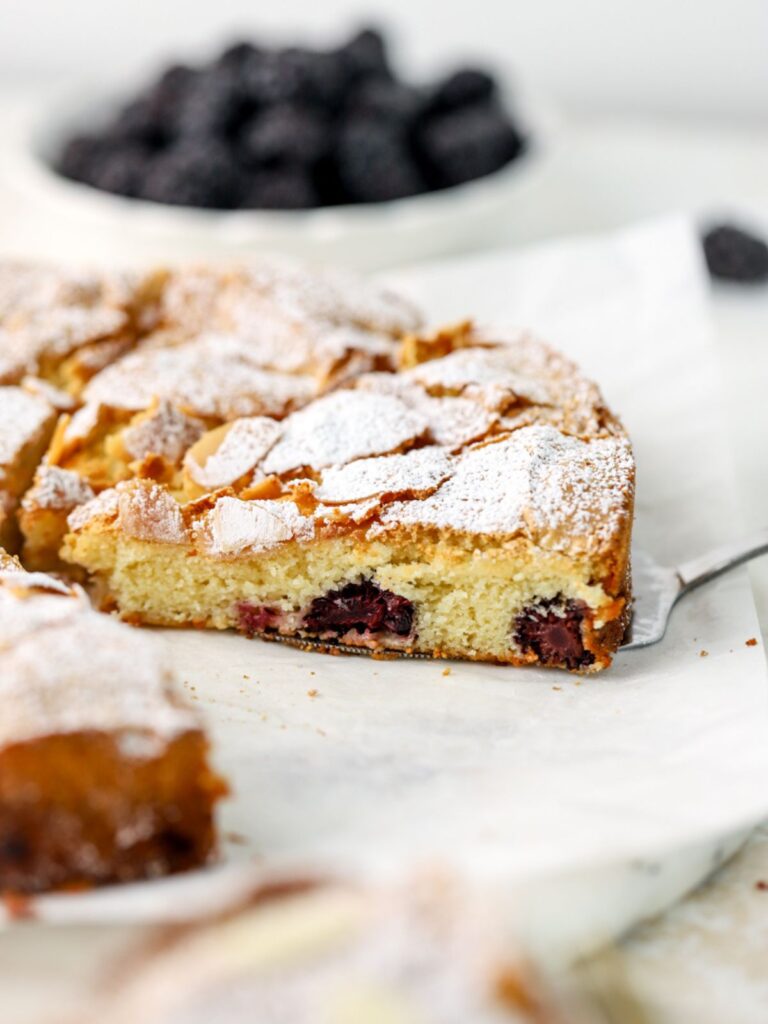 Blackberry cake cut into slices on a white platter. 
