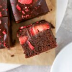 Brownies with chopped strawberries and ganache on top.