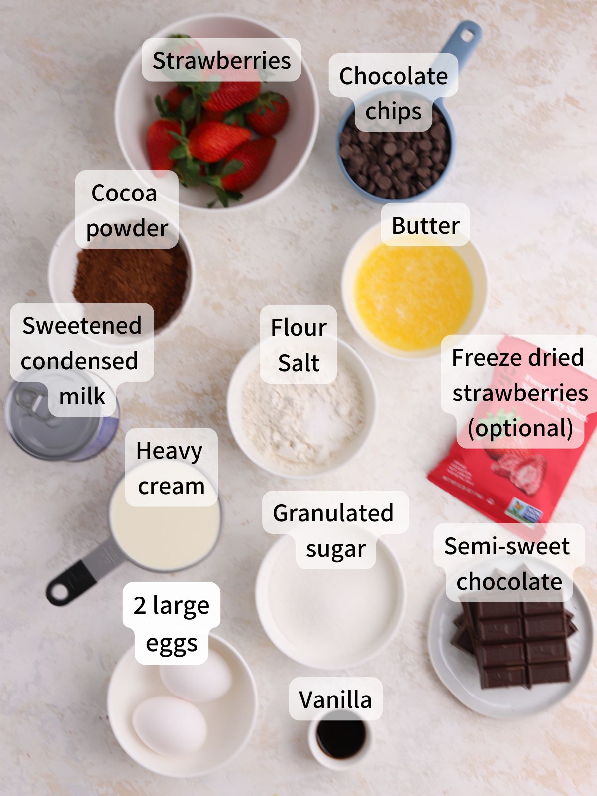 Labeled ingredients needed to make strawberry brownies laid out on a table.