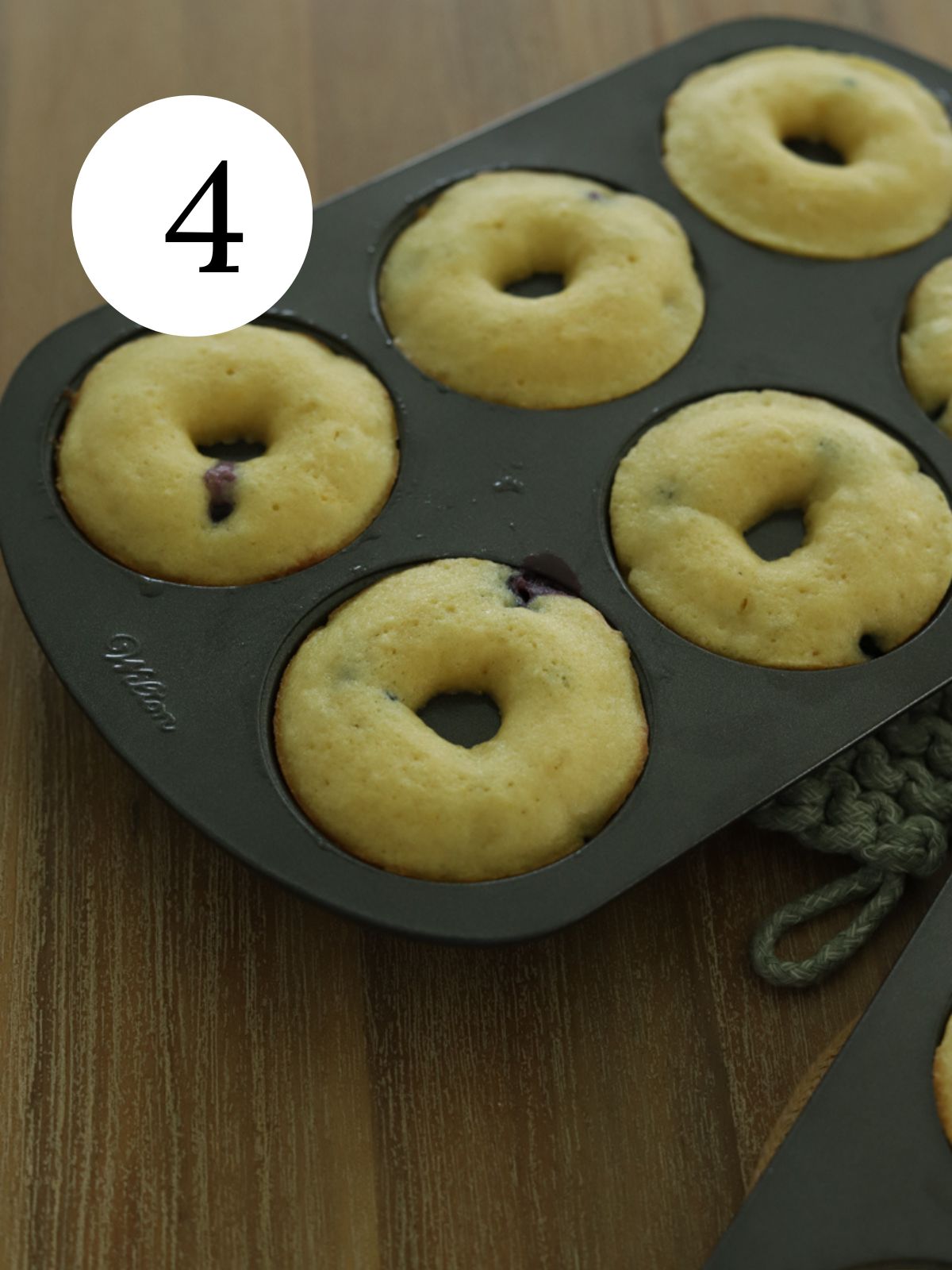 Baked blueberry donuts in a cake pan. 