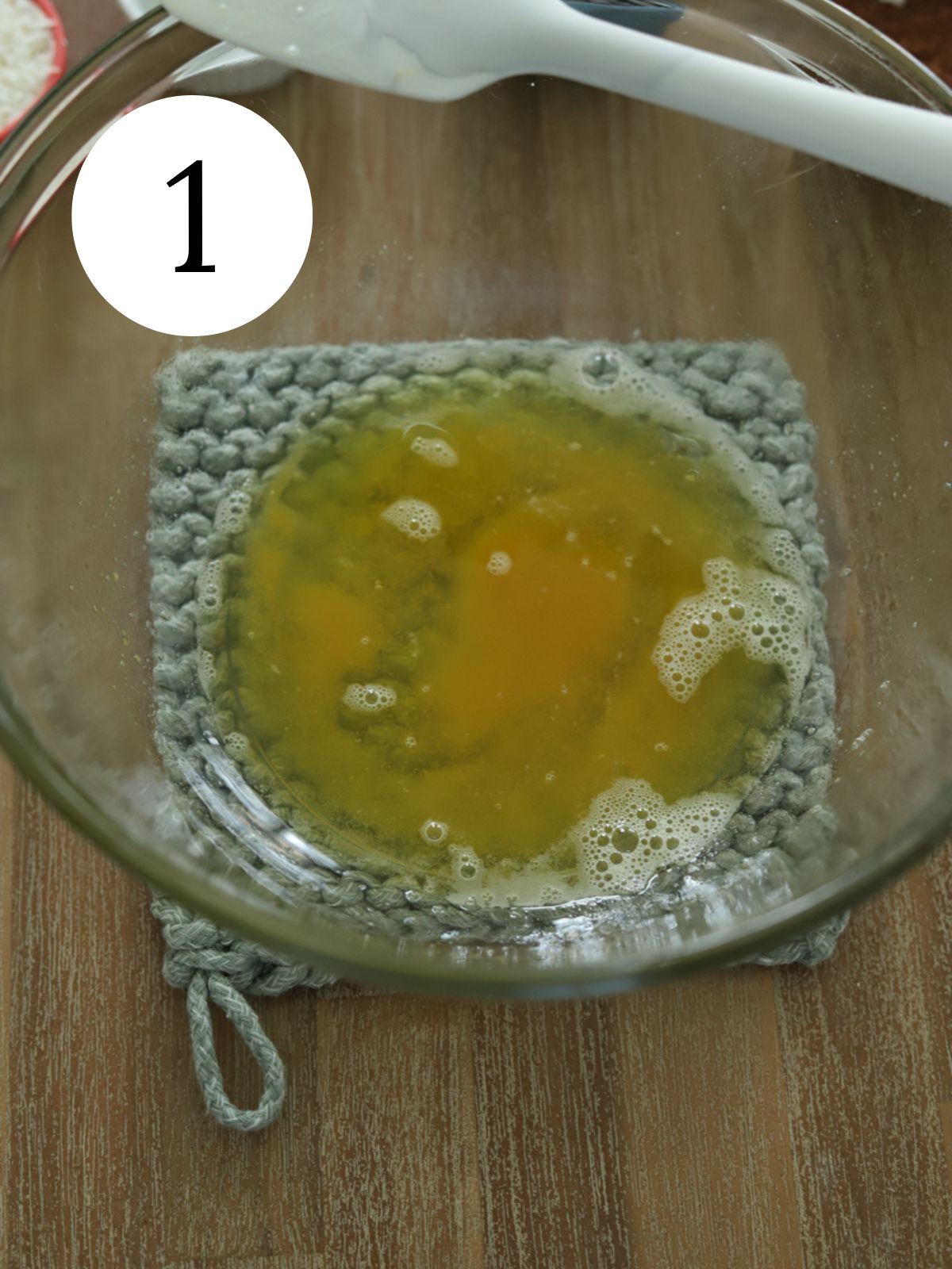 A large glass bowl with brown butter in it set on a pot holder. 