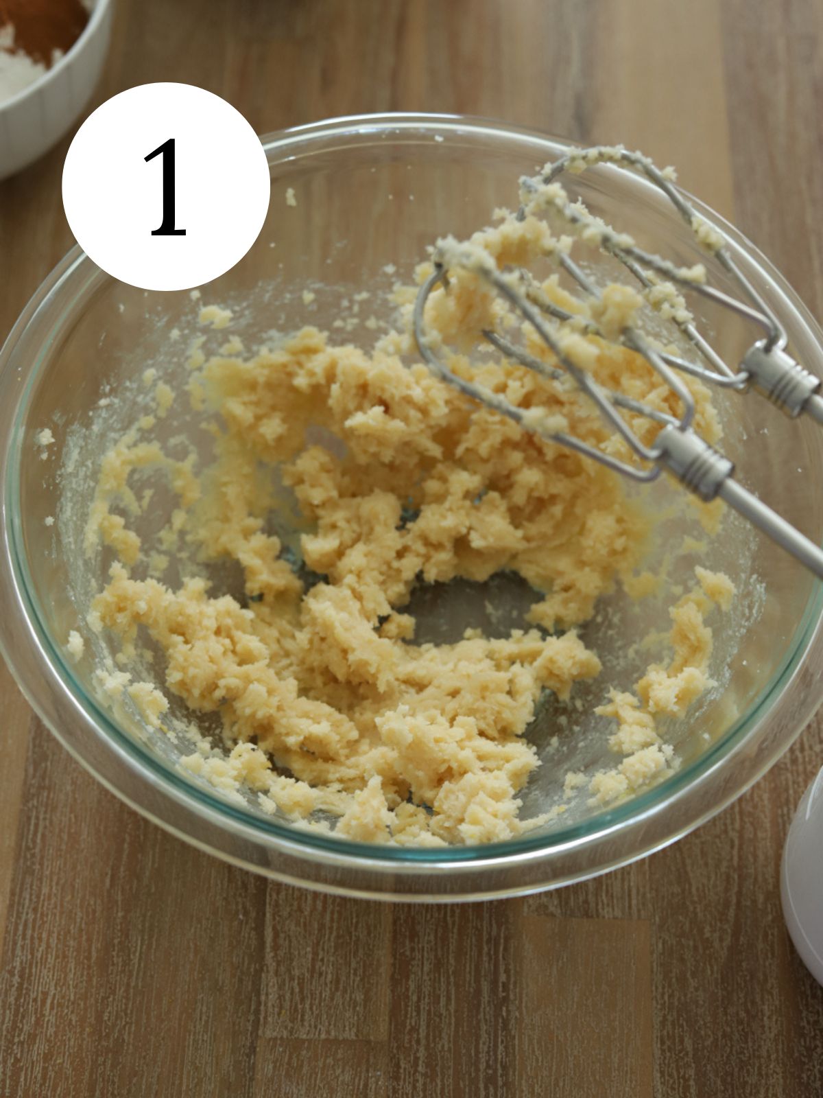 Butter and sugar creamed together with a mixer in a bowl. 