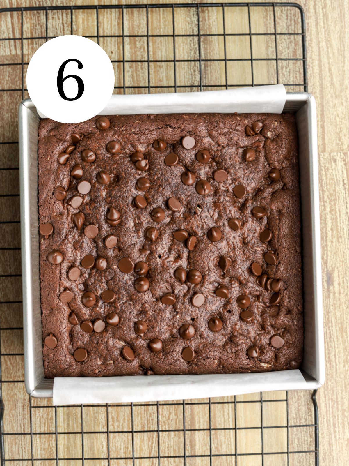 Chocolate chocolate chip cookie dough bars in a pan set on a wire rack. 