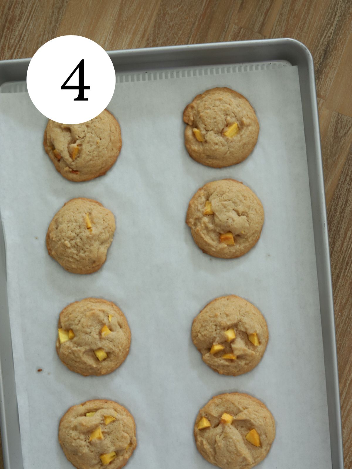 Freshly baked peach cobbler cookies on a baking sheet. 