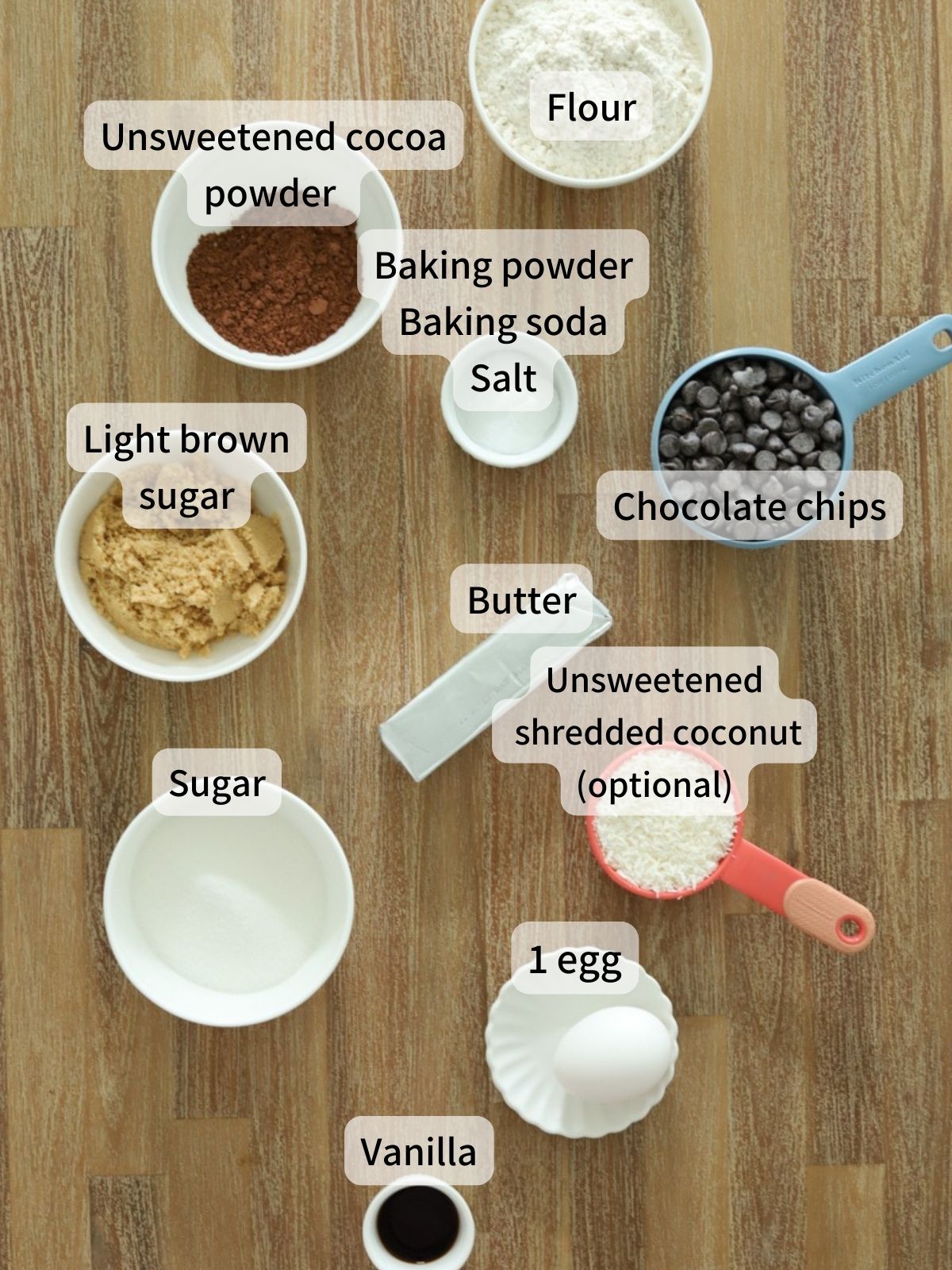 Labeled ingredients needed to make double chocolate chip cookie bars laid out on a table. 
