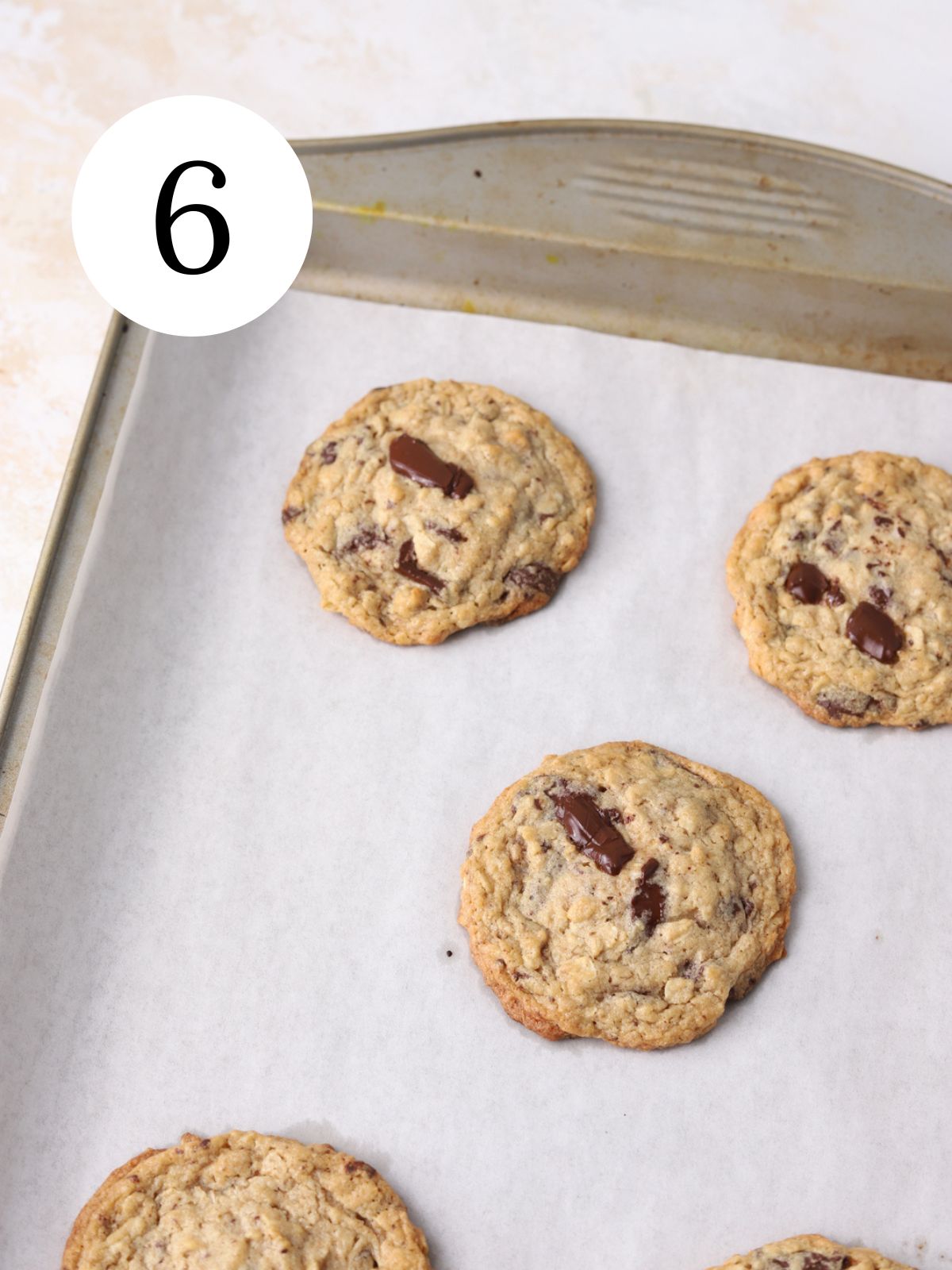 A baking sheet with freshly baked tahini chocolate chip cookies on it.