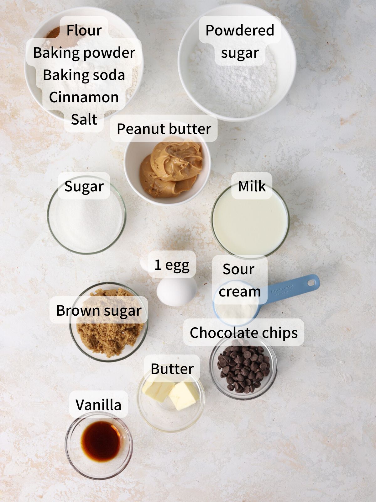 Labeled ingredients needed to make peanut butter donuts laid out on a table. 