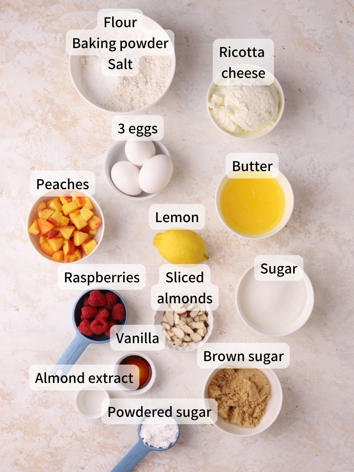 Labeled ingredients needed to make peach raspberry cake laid out on a table.