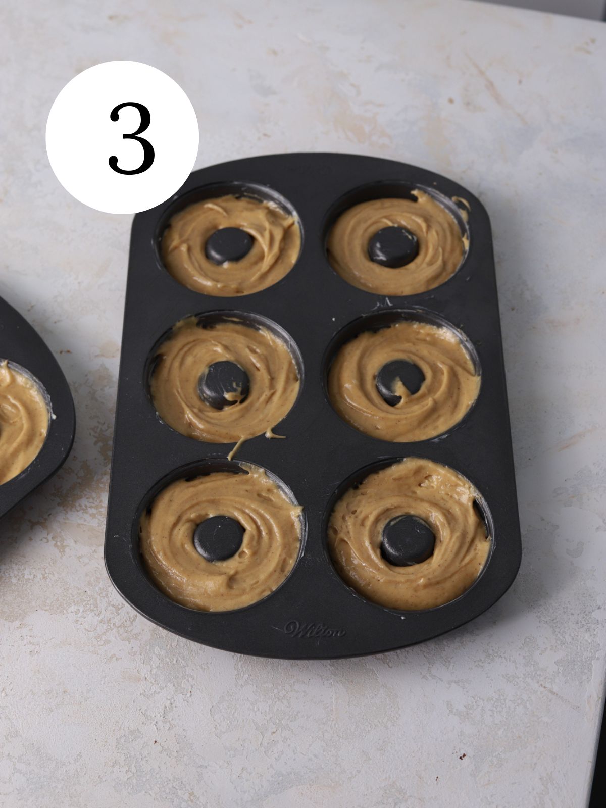 A donut pan filled with donut batter. 