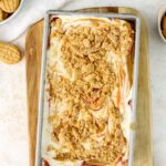 Peanut butter and jelly ice cream in a loaf pan topped with crushed cookies.