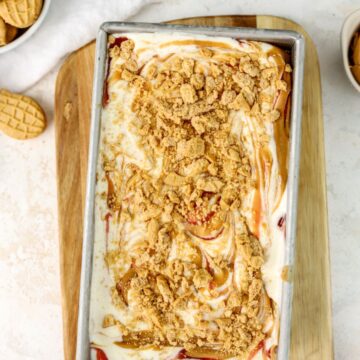 Peanut butter and jelly ice cream in a loaf pan topped with crushed cookies.