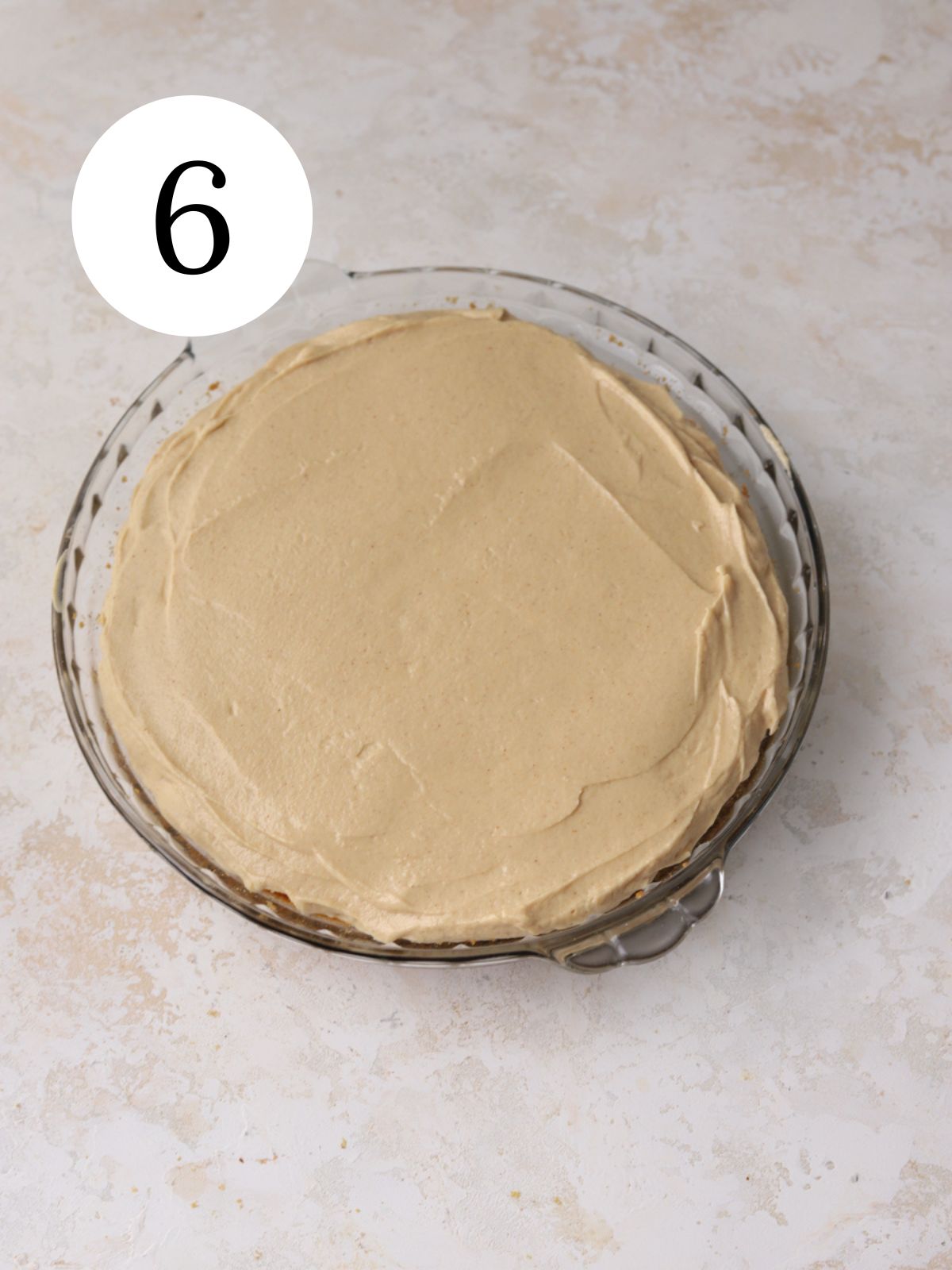 A peanut butter pie in a glass pie plate. 