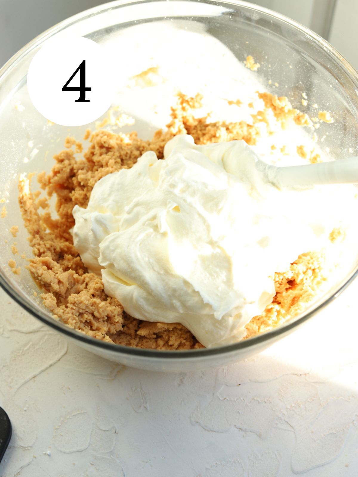 Peanut butter filling with whipped cream on top and a spatula.