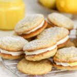 A batch of lemon whoopie pies on a rack.