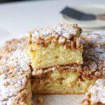 Squares of coffee cake topped with almond streusel and powdered sugar.