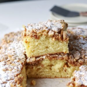 Squares of coffee cake topped with almond streusel and powdered sugar.