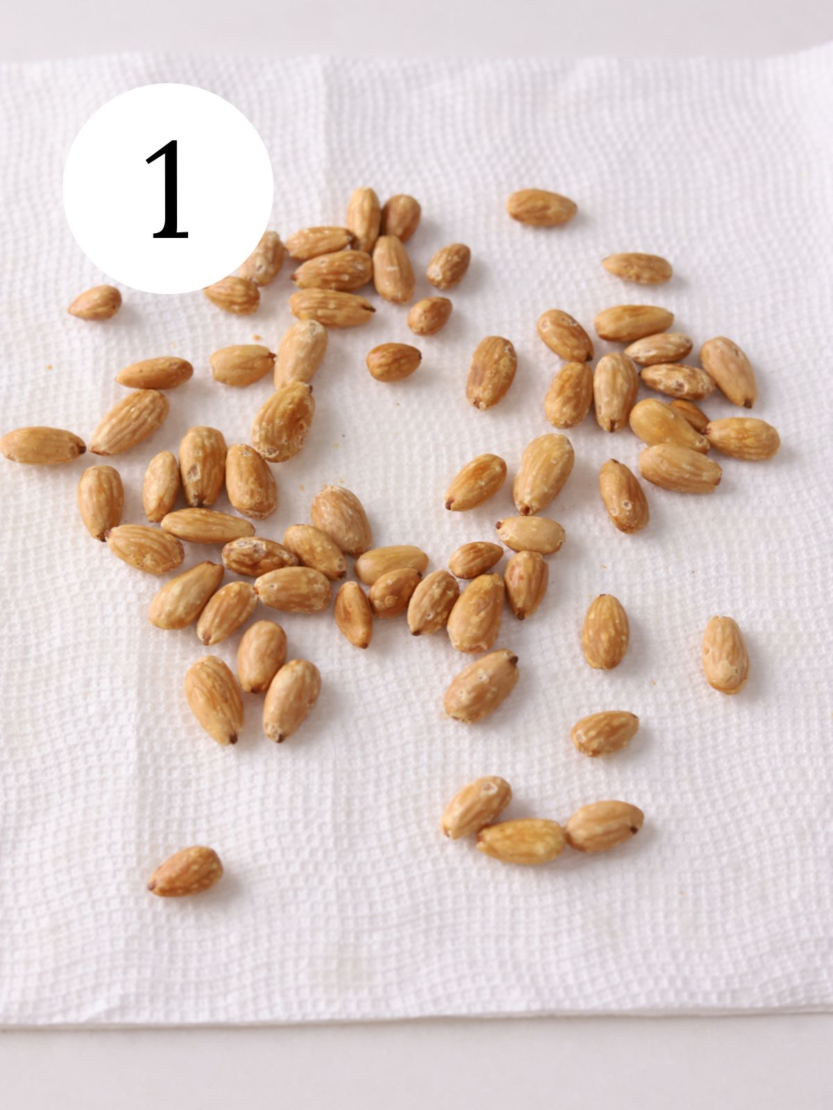 Blanched and fried almonds on paper towels.