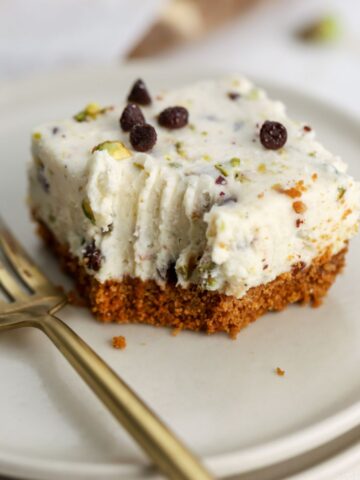 A cannoli bar topped with chocolate chips on a plate with a fork.
