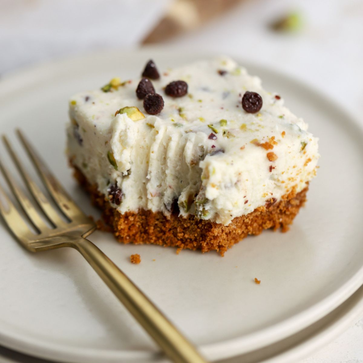 A cannoli bar topped with chocolate chips on a plate with a fork.