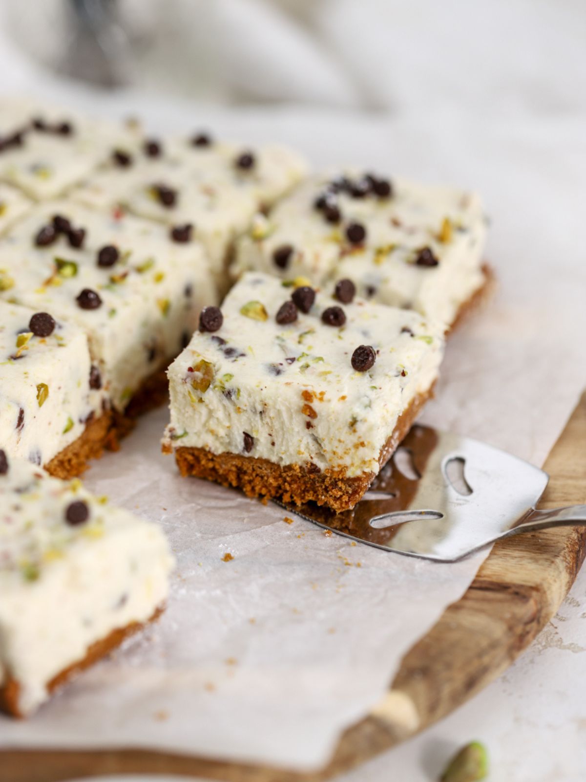A cannoli bar topped with chocolate chips and pistachios being served. 