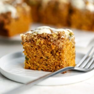 A piece of carrot coffee cake on a plate with a fork.