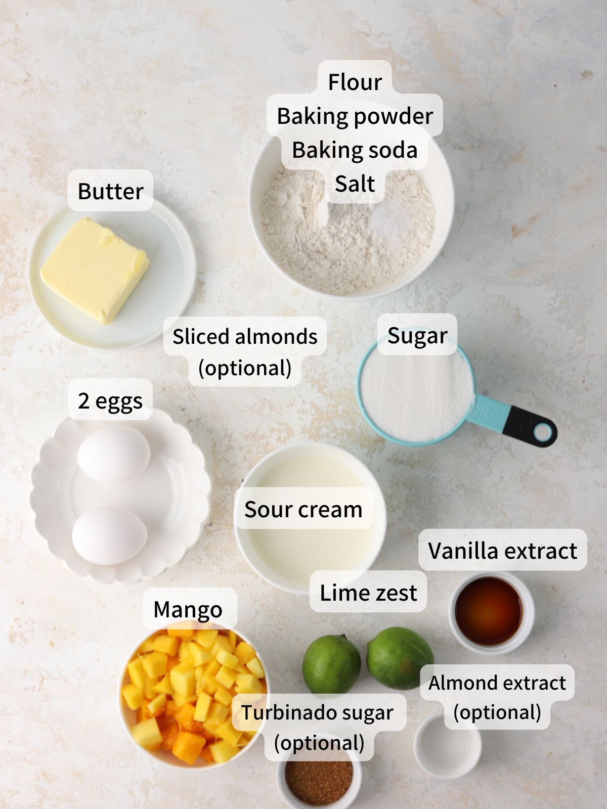 Labeled ingredients needed to make mango bread laid out on a table.