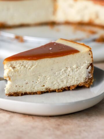 A piece of brown butter cheesecake topped with caramel sauce.