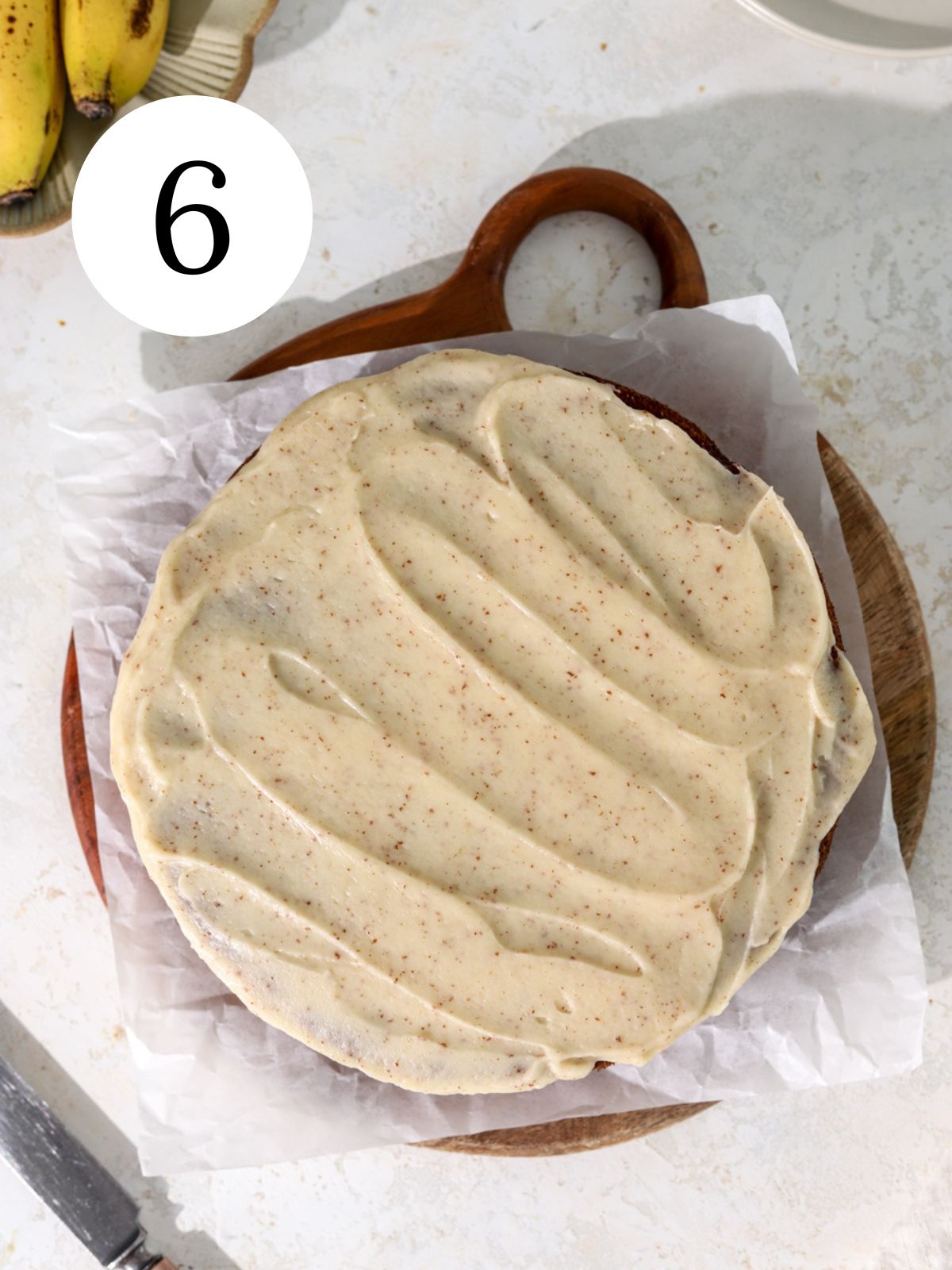A banana cake with brown butter glaze on parchment paper.