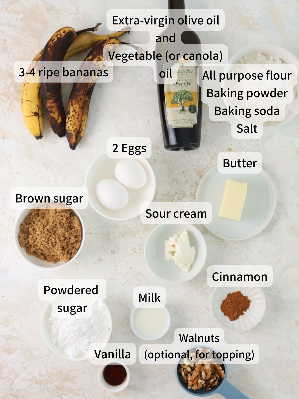 Labeled ingredients needed to make banana olive oil cake laid out on a table.