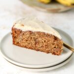 A slice of banana cake on a stack of two plates.