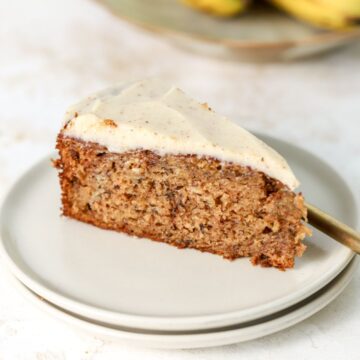A slice of banana cake on a stack of two plates.