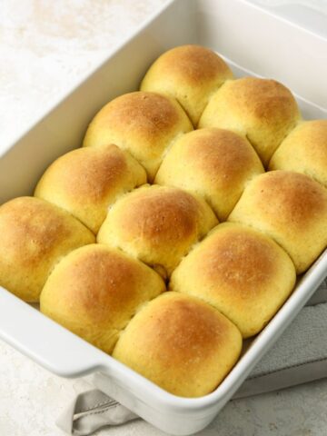 A batch of golden squash rolls in a rectangular pan.