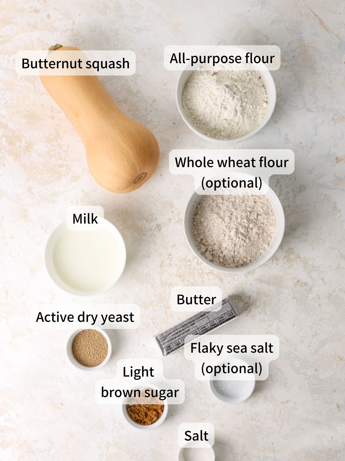 Labeled ingredients needed to make butternut squash rolls laid out on a table.